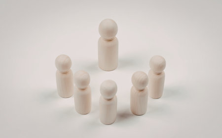 An image of six plain wooden peg dolls arranged in a circle against a white background. The dolls are simple and unpainted, featuring cylindrical bodies and round heads.の写真素材