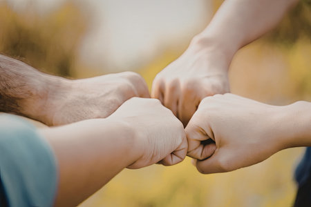 An image depicting a group of people engaging in a celebratory fist bump, symbolizing teamwork, unity, and camaraderie.の写真素材