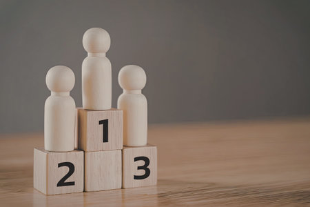 Three wooden peg figures standing on wooden blocks with the numbers 1, 2, and 3. The scene is set against a plain background, highlighting the simplicity and minimalism of the arrangement.の写真素材