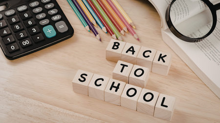 An image of wooden blocks arranged to spell out 'BACK TO SCHOOL' on a wooden desk. The desk also...