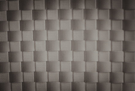 A close-up view of a monochromatic, textured surface featuring a repeating pattern of squares and rectangles. The image is in black and white, showcasing varying shades of gray.の写真素材