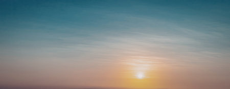 A serene image capturing the sunset over a calm sea. The sky is painted with hues of orange and...