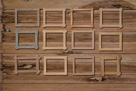 A collection of wooden picture frames in various sizes and colors arranged on a rustic wooden wall.