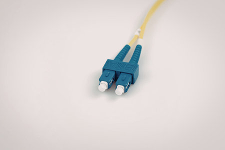 A detailed close-up of a blue fiber optic cable with a yellow jacket, highlighting the connectors...