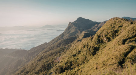 A serene mountain landscape with lush green vegetation, overlooking a sea of clouds. The image...