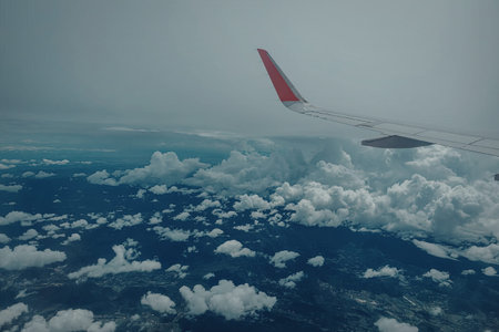 A breathtaking view from an airplane window showcasing the wing and a sea of clouds below.