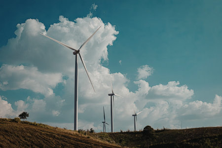 A serene landscape featuring multiple wind turbines standing tall against a bright blue sky with...