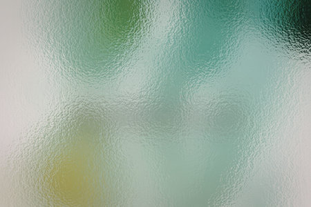 A visually appealing abstract background featuring a blend of green and white hues with a textured glass effect, creating a calming and serene atmosphere.の写真素材