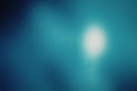 A vibrant blue background with a bright white light shining through, creating a sense of depth and illumination.の写真素材