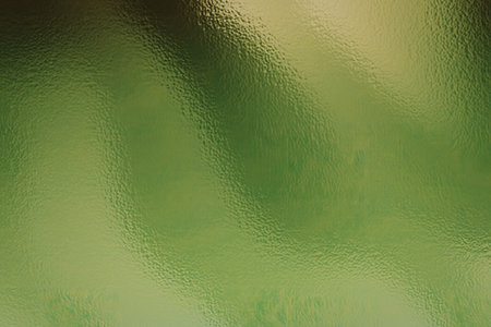 A close-up image of a vibrant green metallic surface with a gradient effect and shiny texture, creating a visually appealing and dynamic background.の写真素材