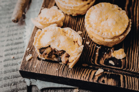 a cutting board with some mini meat pies on it, one of them cut openの写真素材