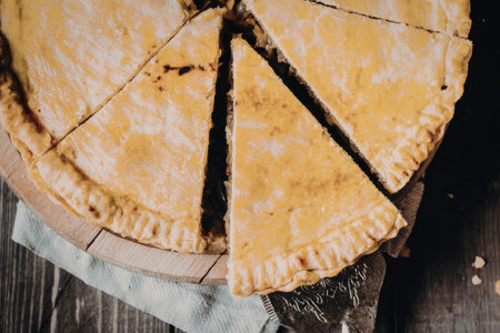 A mouthwatering image of a pie cut into slices, showcasing its golden brown crust and savory filling.の写真素材