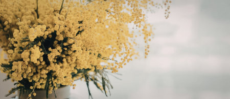 A bouquet of bright yellow flowers in a vase on a white backgroundの写真素材