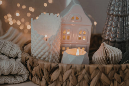 A warm and inviting scene featuring lit candles and soft lighting in a woven basket, surrounded by decorative items.の写真素材