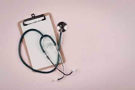 A clipboard with a stethoscope on a pink backgroundの写真素材
