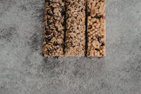 An image of three granola bars placed side by side on a gray textured surface.の写真素材