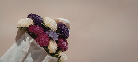 A close-up of a hand adorned with a vibrant floral wreath made of purple, pink, and white flowers...