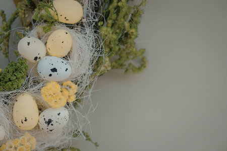A close-up of a nest on moss with yellow, white and speckled eggs.
