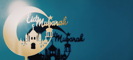 A digital illustration for Eid Mubarak featuring a crescent moon, mosque silhouette, and festive...