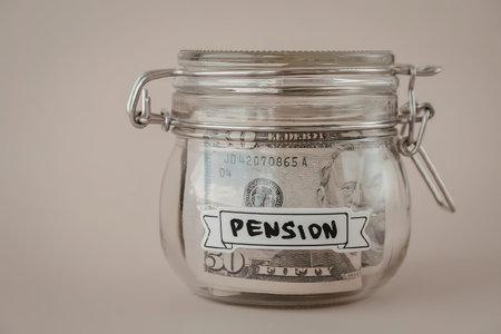 A glass jar with a metal clasp containing banknotes labeled as pension savings