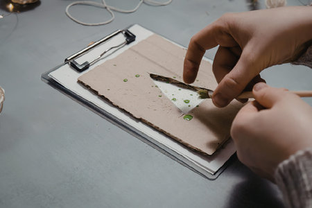 A person cutting a piece of paper on a clipboard.