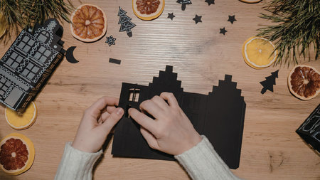A pair of hands holding puzzle pieces on a wooden table surrounded by festive decorations