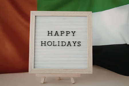 A festive holiday greeting sign with the UAE flag in the backgroundの写真素材