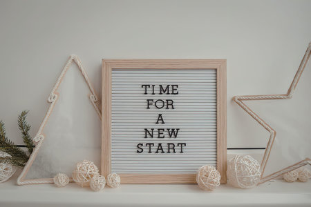 A motivational letter board with the phrase 'Time for a New Start' surrounded by decorative items on a shelf.の写真素材
