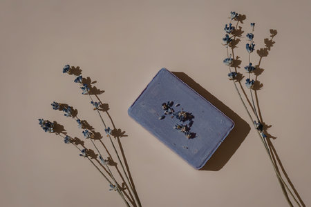 A purple soap bar with dried lavender flowers on a beige backgroundの写真素材