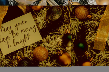 A close-up of a Christmas tree with a white card that reads 'May your days be merry & bright'...