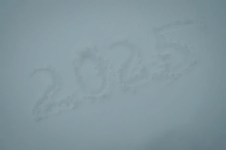 The image shows the year 2025 written in the snow.