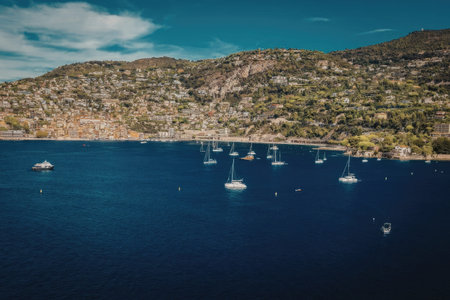 a large body of water with boats sailing on it and a mountain range in the backgroundの写真素材