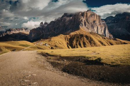 A scenic view of a mountain range with a winding road in the foreground, surrounded by grassy hills...