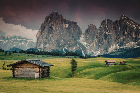 A serene mountain landscape featuring a rural hut in a green field with majestic mountains in the...