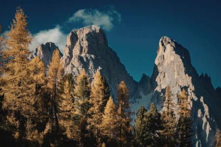 A scenic view of rugged mountain peaks with trees displaying vibrant autumn colors in the...