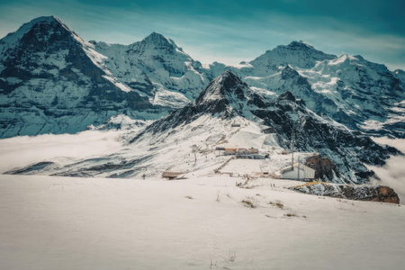 A breathtaking landscape of snow-covered mountains under a clear blue sky, with a serene and peaceful atmosphere.の写真素材