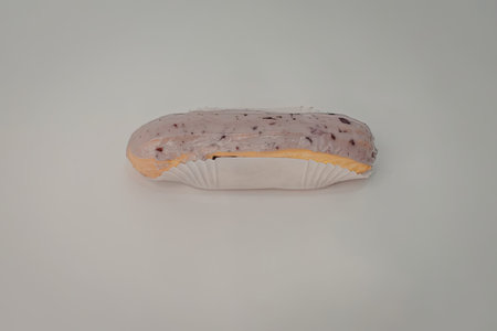A single glazed donut with purple and pink sprinkles on top, placed on a white surface.