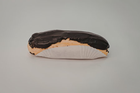 A small toy fish with a black back, white belly, and orange fins, lying on a plain gray surface.