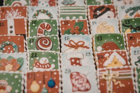 A close-up view of a Christmas advent calendar featuring 24 small doors with various holiday-themed...