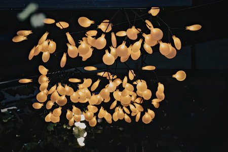 The image depicts numerous orange lights falling down in the darkness, creating a mesmerizing scene.