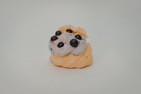 A small clay sculpture of a dog's face with a yellow base and white face