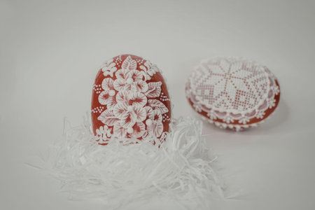 Two red and white floral patterned decorations with a white fringe