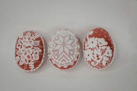 Three red and white decorative eggs with intricate designs