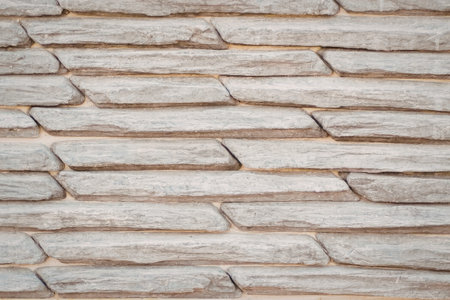 A close-up view of a stacked stone wall with light-colored stones.