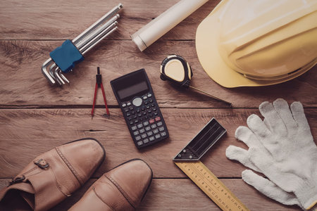 A collection of construction tools and equipment laid out on a wooden surface