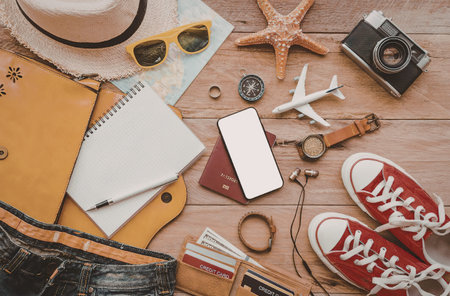 A collection of travel items including a hat, sunglasses, camera, notebook, and shoes.