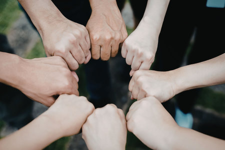 A close-up image of multiple hands clasped together in a symbol of unity and support.