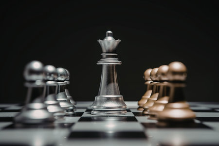 A close-up of chess pieces on a board, featuring a silver queen, pawns, and a gold pawn.