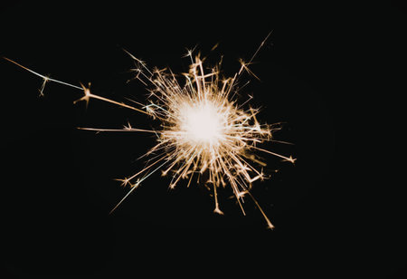 A bright sparkling firework exploding on a black background, creating a vibrant display of light and...