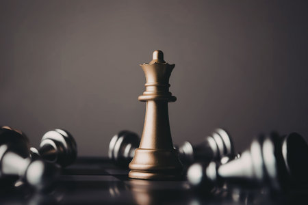 A close-up of a chessboard with a single gold king piece standing among fallen silver pieces, set...